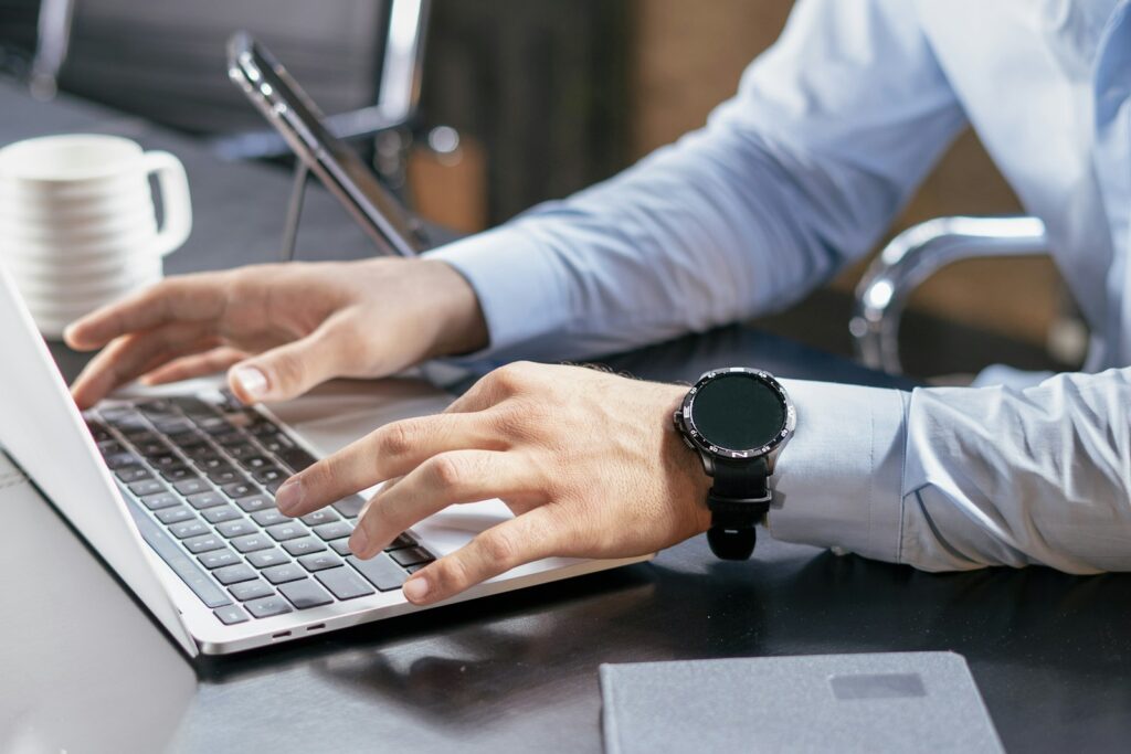 Person typing on a laptop at a desk, updating training modules after a rule change