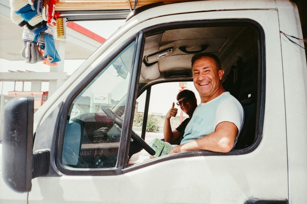 Man driving a white van giving a thumbs up, representing a trade business on the road