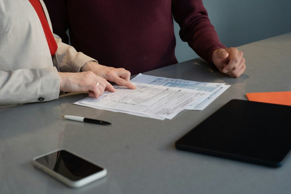 Two professionals reviewing paperwork at a conference table, much like assessing a case before funding it