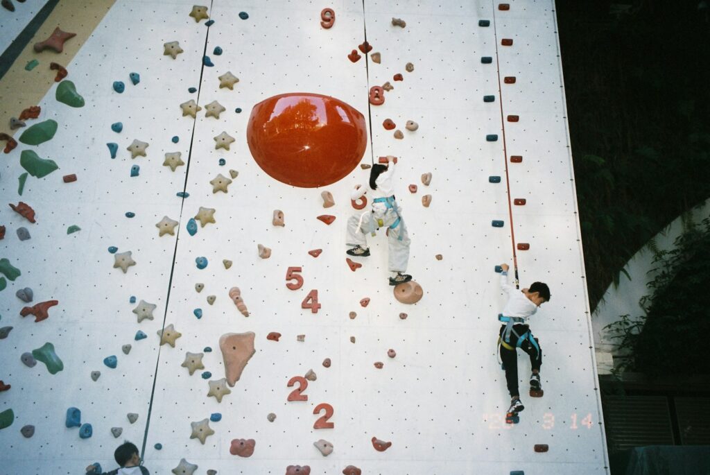 Children climbing a colourful indoor rock wall, a fun active setting for a birthday party
