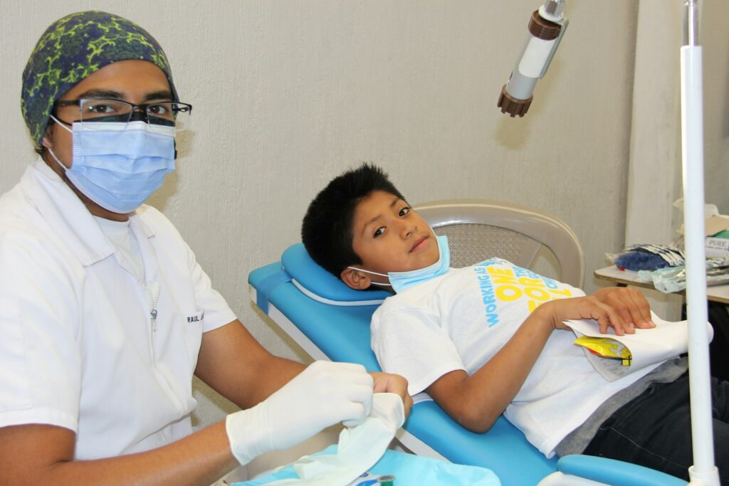 Young boy having his teeth checked by a dentist during a check-up
