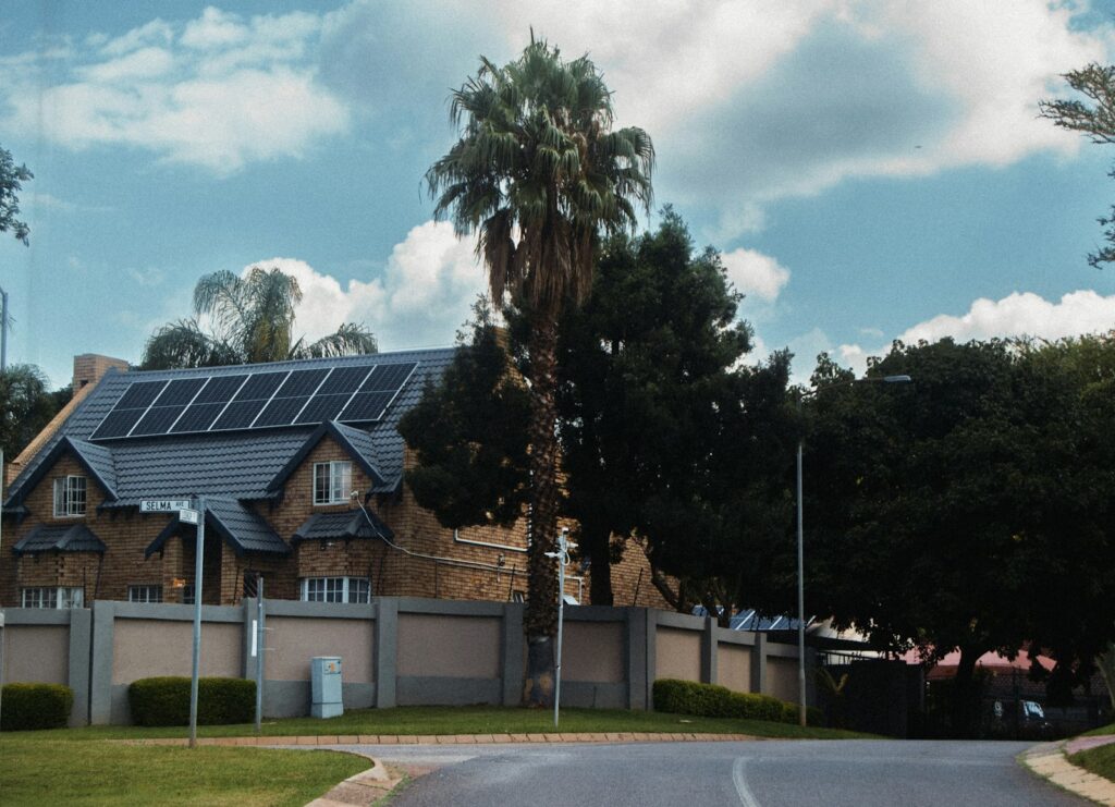 Large house with solar panels on the roof, representing installing solar now rather than waiting